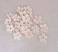 small crocheted flowers sitting on top of a white surface with no one around them