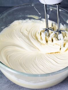 a mixer mixing cream in a glass bowl