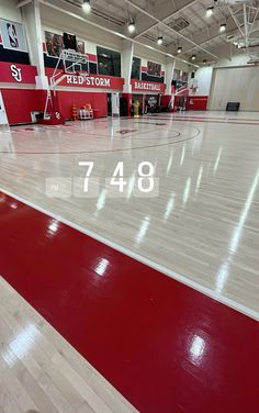 an indoor basketball court with white and red floors