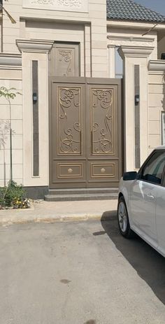 a white car parked in front of a building with two doors on it's side