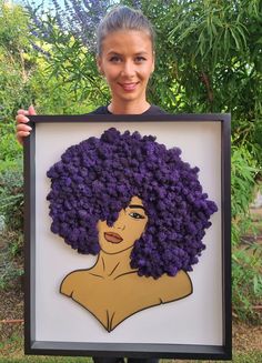 a woman is holding up a framed painting with purple flowers on it's head