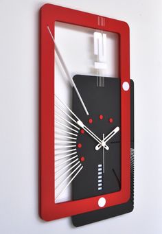 a red and black clock mounted to the side of a wall