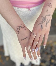 a woman's hand with tattoos on her left and right palm, holding onto the wrist