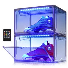 two clear boxes with shoes in them and remotes on the side, all lit up