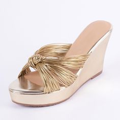 a woman's gold wedged sandal with tassels on the side