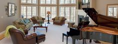 a living room filled with furniture and a grand piano