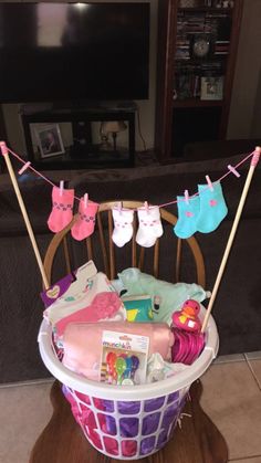 a basket filled with baby items on top of a wooden table next to a tv