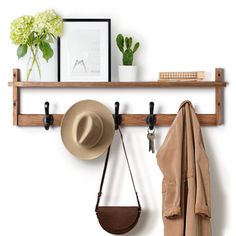 a hat, coat rack and other items are hanging on the wall next to each other