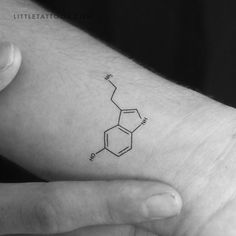 a person's hand with a small tattoo on their left wrist that has the chemical structure of caffeine in it