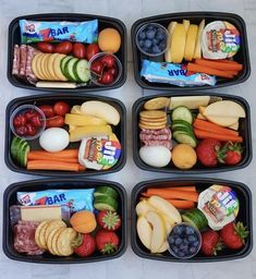 four plastic trays filled with different types of food and snacks on top of each other