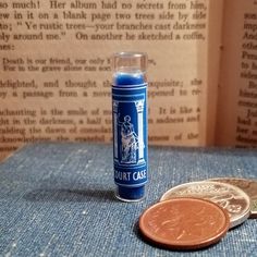 a penny sitting on top of a blue cloth next to a roll of toilet paper