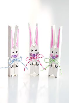 three bunny shaped paper bags tied to each other with colorful ribbons on the handles and ears