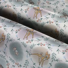 an image of fabric with animals and flowers on it's surface in pastel colors