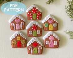 a group of gingerbread house ornaments hanging from a christmas ornament on a wall