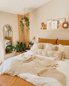 a bedroom with a bed, mirror and potted plants