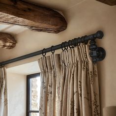 the curtains are hanging on the rod in front of an open window with wood beams