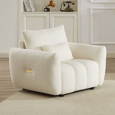 a white chair sitting on top of a wooden floor next to a book shelf filled with books