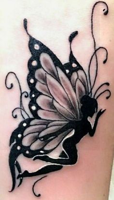 a black and white butterfly tattoo on the back of a woman's thigh,