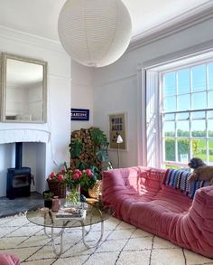 a living room filled with furniture and a fire place in front of a large window