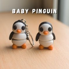 two little penguin key chains sitting on top of a table