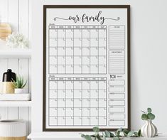 a printable calendar hangs on the wall next to a potted plant and bookshelf