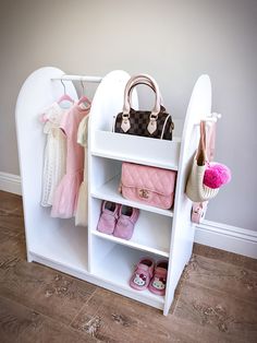 a white shelf with purses and shoes on it