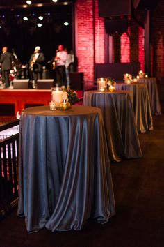 the tables are covered with silver cloths and candles