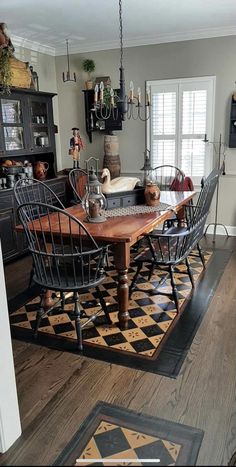 a dining room table with chairs and a rug on the floor in front of it