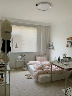 a bedroom with a bed, desk and shelves on the wall in front of a window