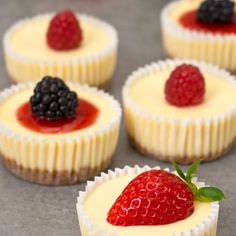 small cupcakes with white frosting and berries on top