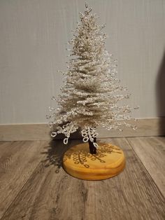 a small white christmas tree sitting on top of a wooden table