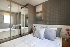 a bedroom with mirrored walls and white bedding