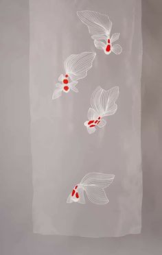 three white and red fish floating on top of a gray wall next to each other