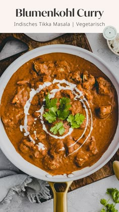 a white bowl filled with curry and garnished with cilantro