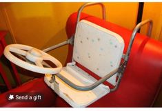 a red seat with a steering wheel attached to it and the words send a gift above it