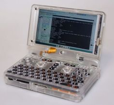 an open laptop computer sitting on top of a white table next to other electronic devices