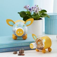 a piggy bank sitting on top of a book next to a potted plant