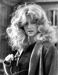 a black and white photo of a woman with long hair holding an umbrella in her hand