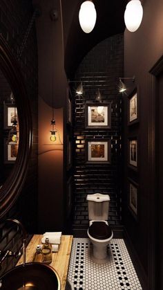 a bathroom with a toilet, sink and pictures on the wall in it's walls