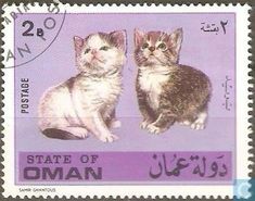 two cats sitting on top of a postage stamp with the word state of oman written in arabic