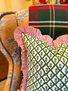 a close up of a pillow on a chair in a room with plaid furniture and christmas decorations