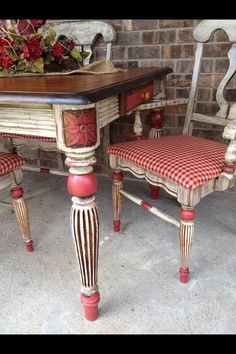 an old table and two chairs with red checkerboard upholstered seat covers