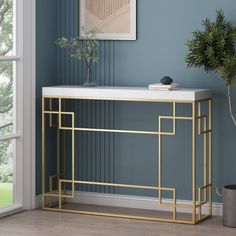 a white and gold console table with a potted plant in the corner next to it