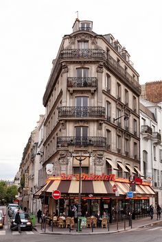 the corner of a building with people walking around it