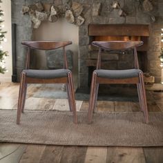 two chairs sitting next to each other in front of a fireplace