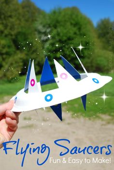 a hand holding up a paper airplane that says flying saucers fun and easy to make