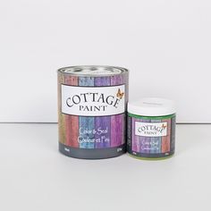 two tins of paint sitting next to each other on a white surface with the words cottage paint in it