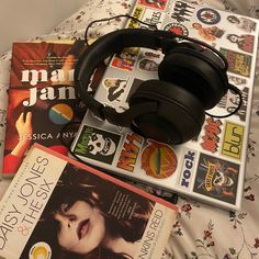 some books and headphones on a bed