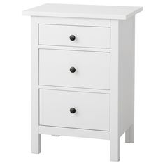 a white nightstand with three drawers on it