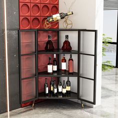 a wine rack with bottles on it in front of a red wall and vases